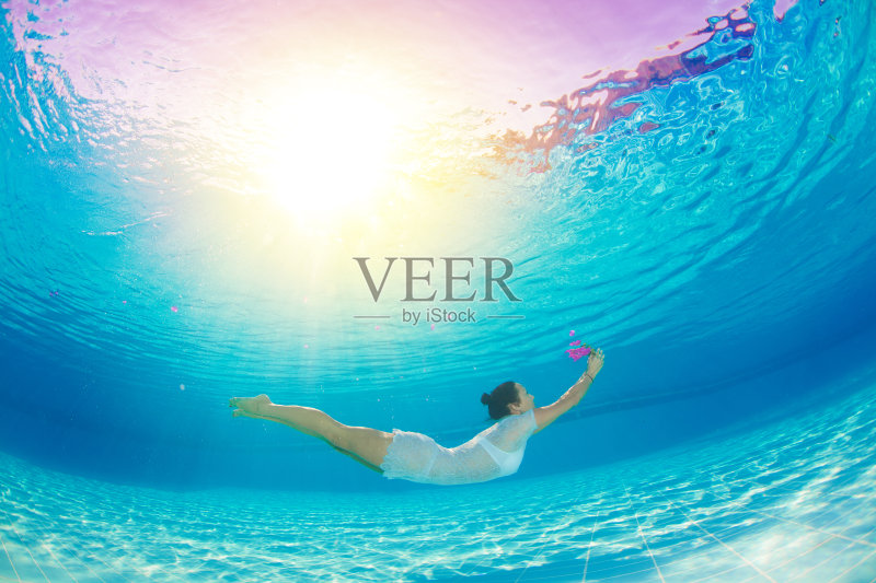 一个女人带着粉红色的花优雅地在水下游泳正版图片素材