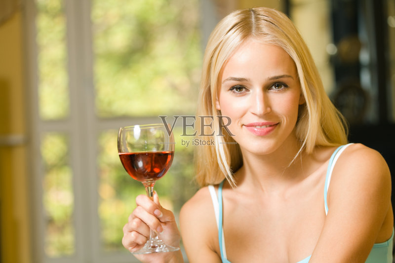 室内,一个年轻漂亮的女人拿着红酒杯正版图片素材