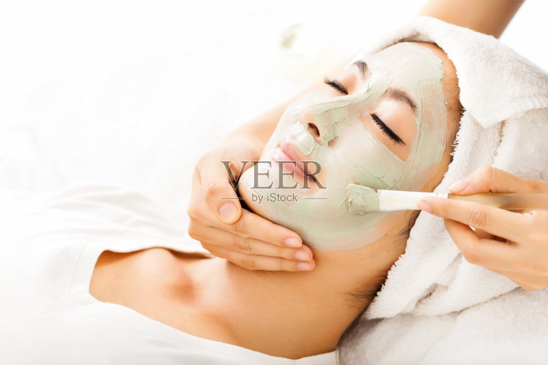 年轻美丽的女人,用粘土面膜正版图片素材