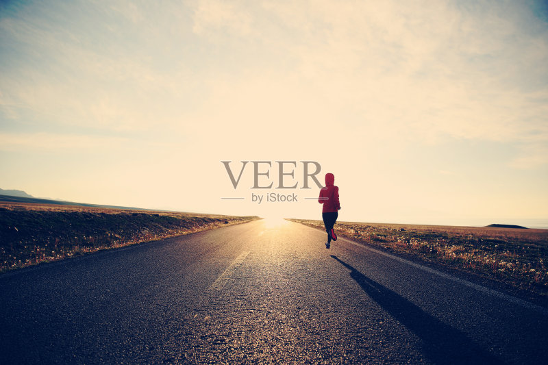 年轻的健身女运动员在公路上跑步正版图片素材