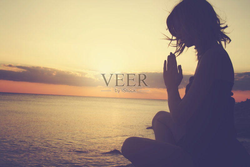 年轻女子在海滩上练习瑜伽。正版图片素材