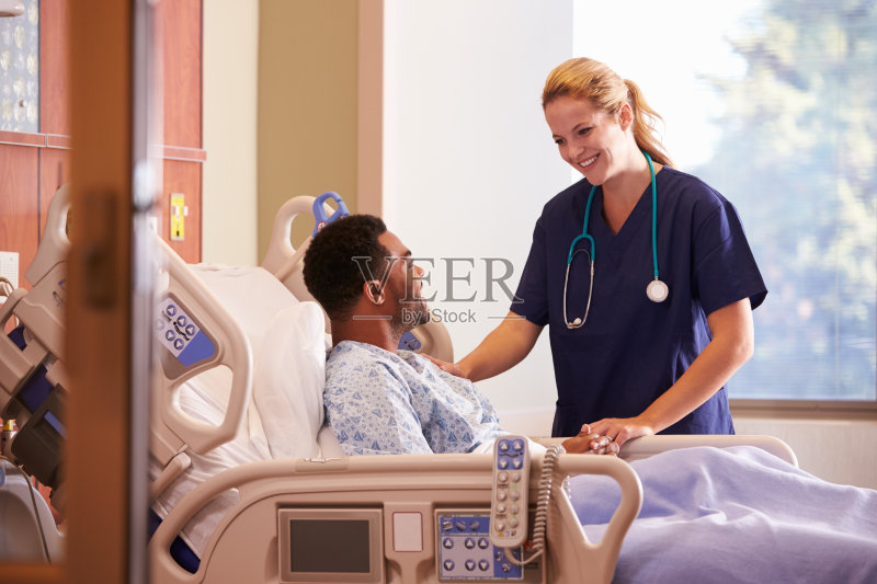 女医生在病床上与男病人交谈正版图片素材