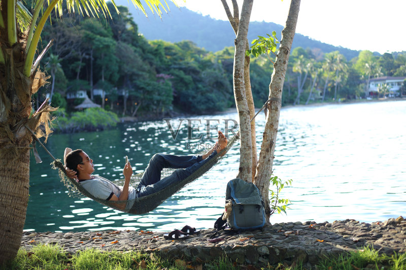 一个人睡在沙滩上的吊床上正版图片素材