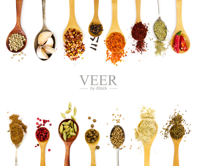 汤匙里的香料在白色背景上分开。正版图片素材