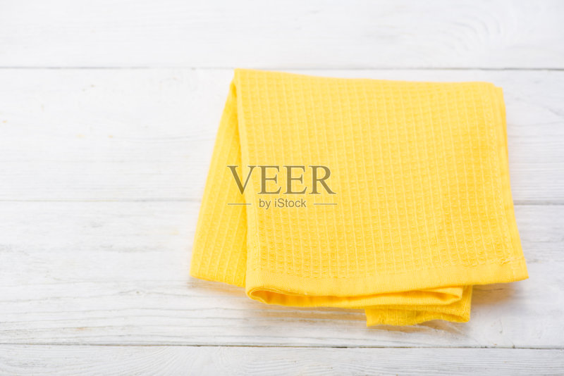 黄色的餐巾孤立在白色的木桌上。副本的空间。前正版图片素材