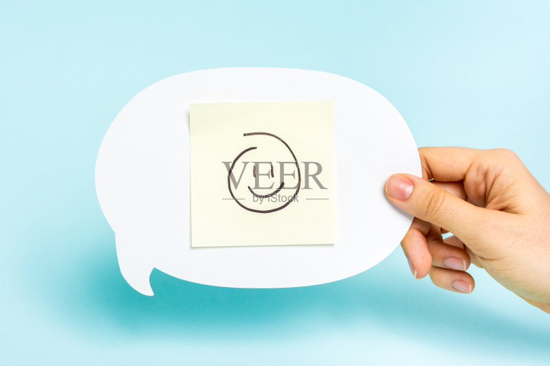 在蓝色背景上的语音泡泡上的快乐表情。正版图片素材