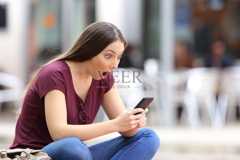 街上有个拿着手机的惊讶女人正版图片素材