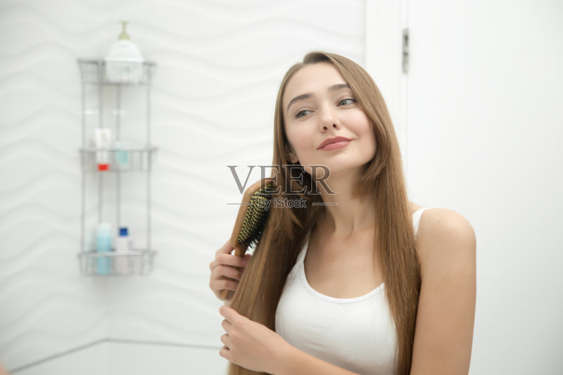 一个微笑的小女孩梳头发的肖像正版图片素材