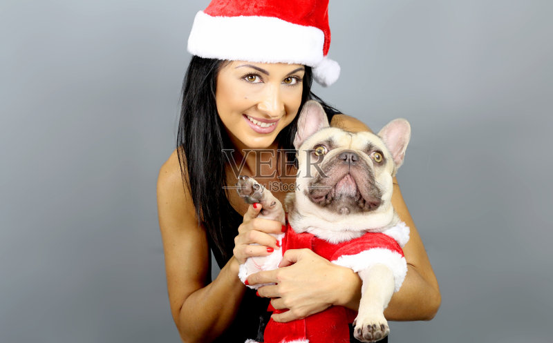 一个女人和他的法国斗牛犬穿着圣诞服装正版图片素材