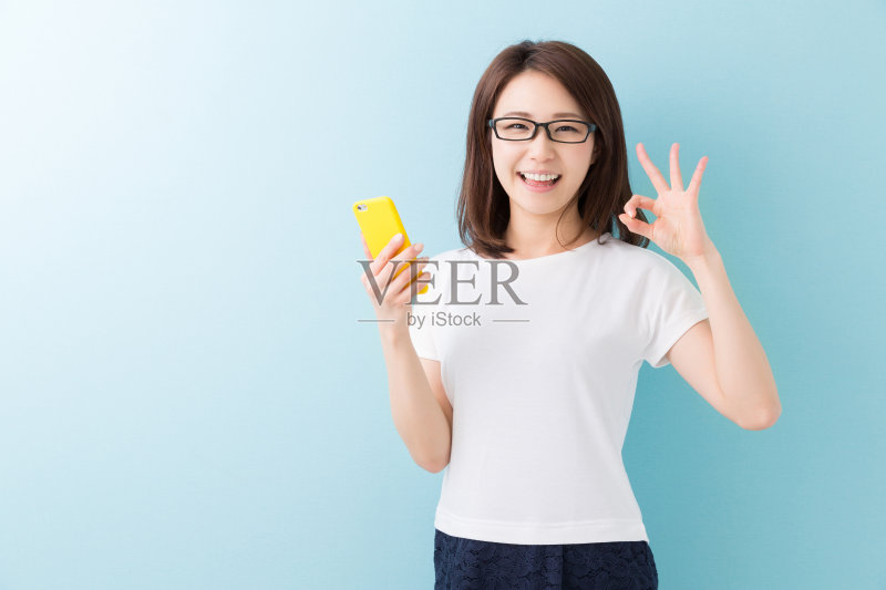 一个拿着智能手机的日本女人正版图片素材