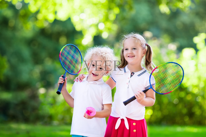 孩子们在户外场地上打羽毛球或网球正版图片素材