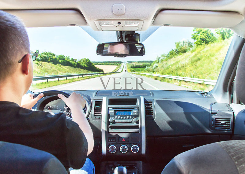 这个男人正在开车,双手放在方向盘上。正版图片素材