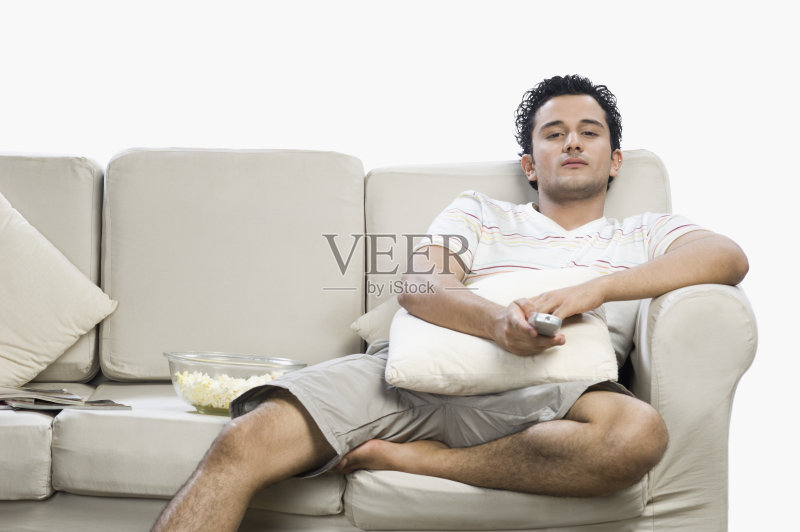 男人看着电视,看起来很惊讶正版图片素材