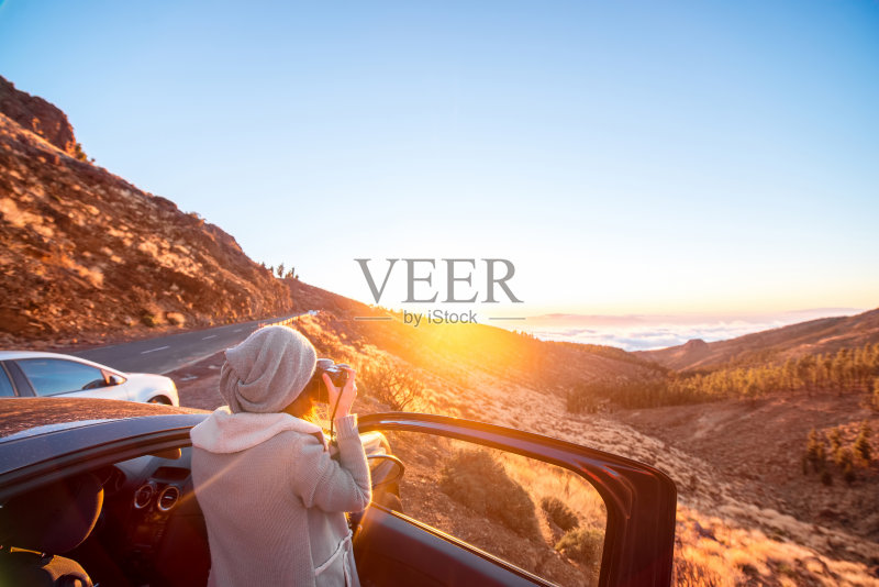 站在车旁拍摄风景的女人正版图片素材