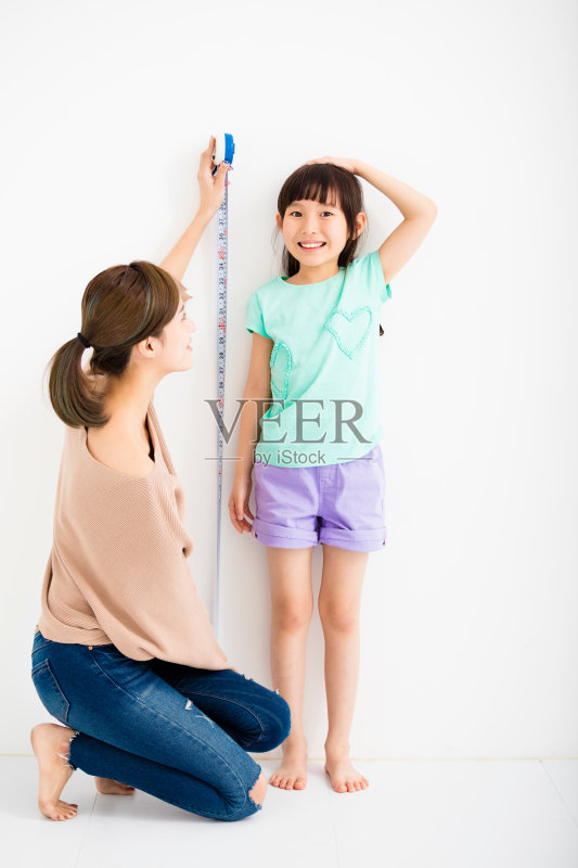 母亲测量女儿的成长正版图片素材