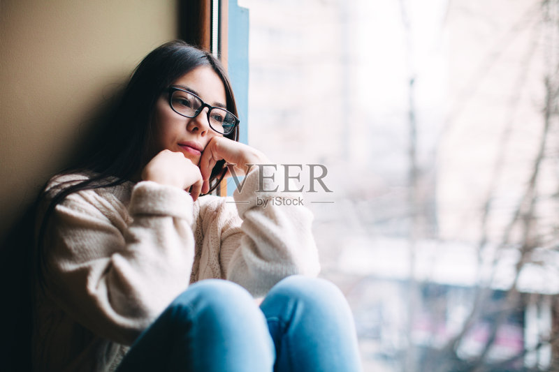 悲伤的女孩望着窗外正版图片素材