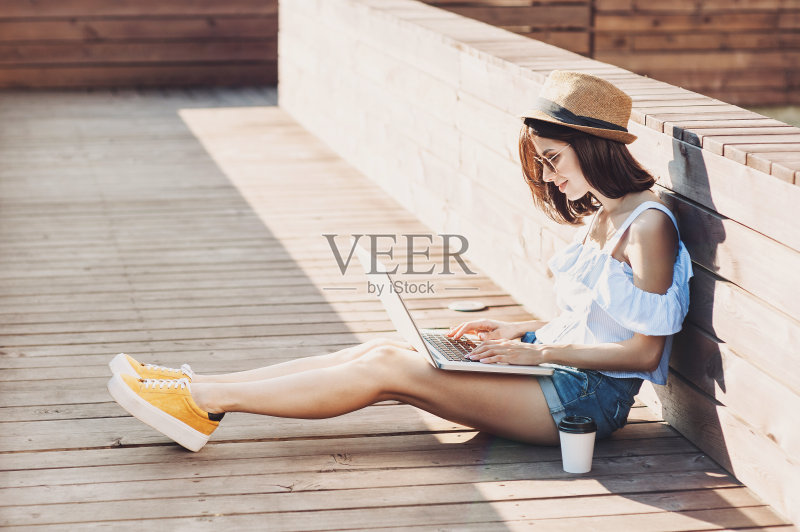年轻时髦的女孩在户外用笔记本电脑正版图片素材
