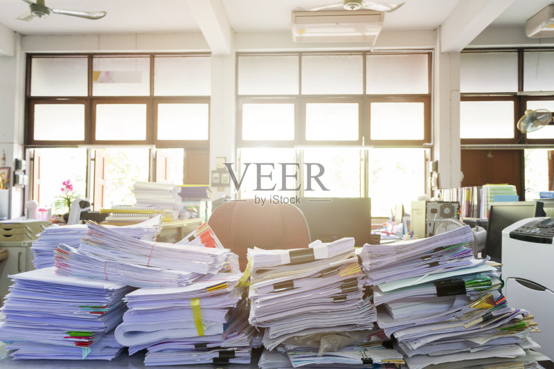 业务概念,办公桌上一堆未完成的文件正版图片素材