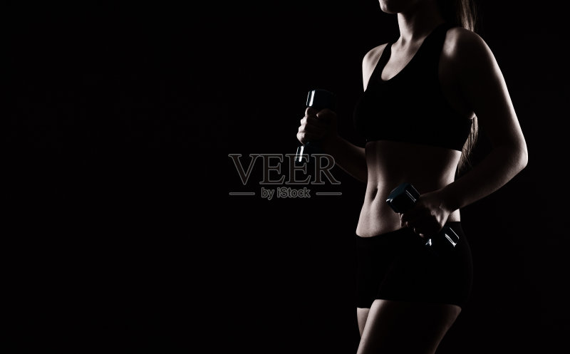 黑色背景下的健身女性正版图片素材