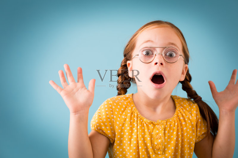 惊讶的年轻女孩戴着复古的书呆子眼镜正版图片素材