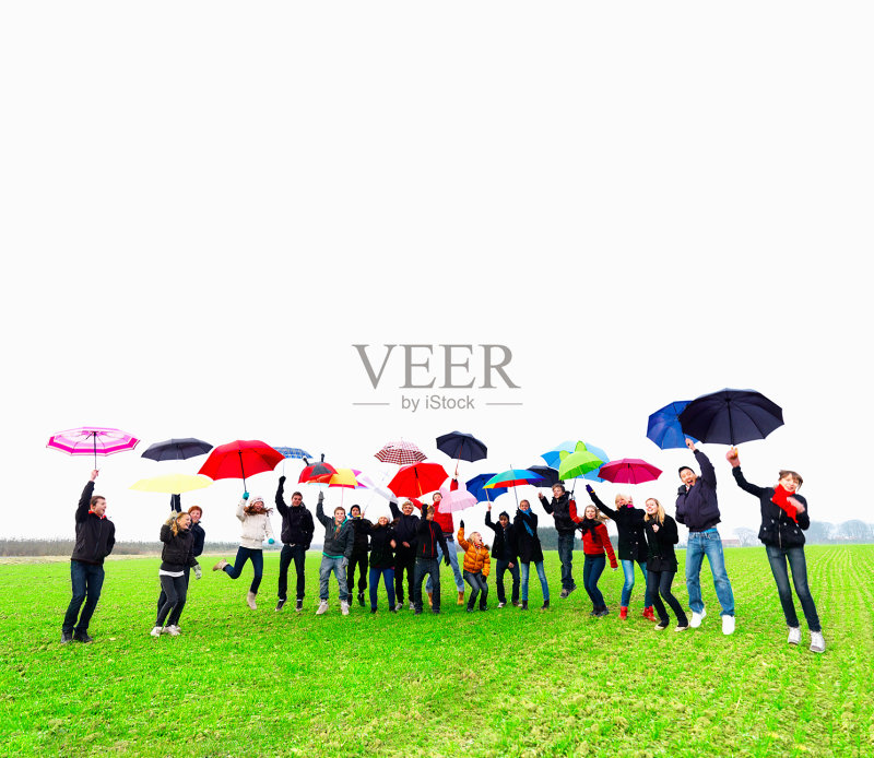 快乐的青少年一边撑伞一边跳正版图片素材