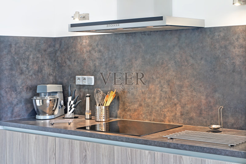 新式的灰色厨房,在抽油烟机旁边有一些炊具正版图片素材