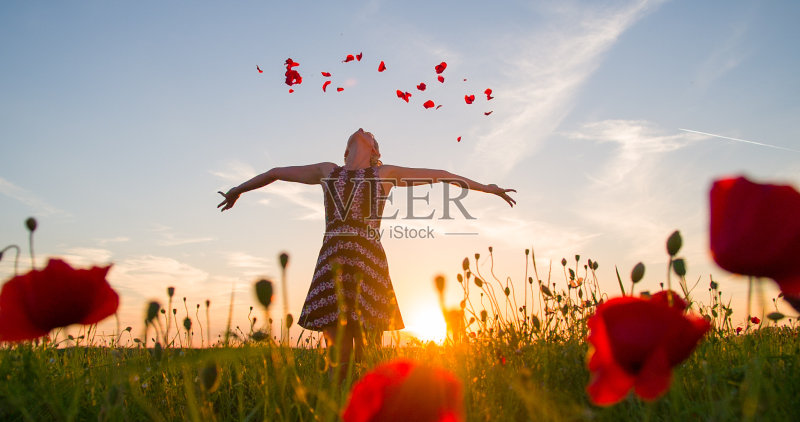 在草地上扔花瓣的女人正版图片素材