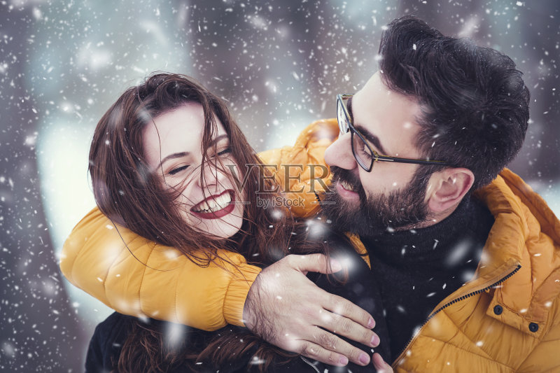 一对浪漫可爱的夫妇在一个下雪的公园里玩耍正版图片素材