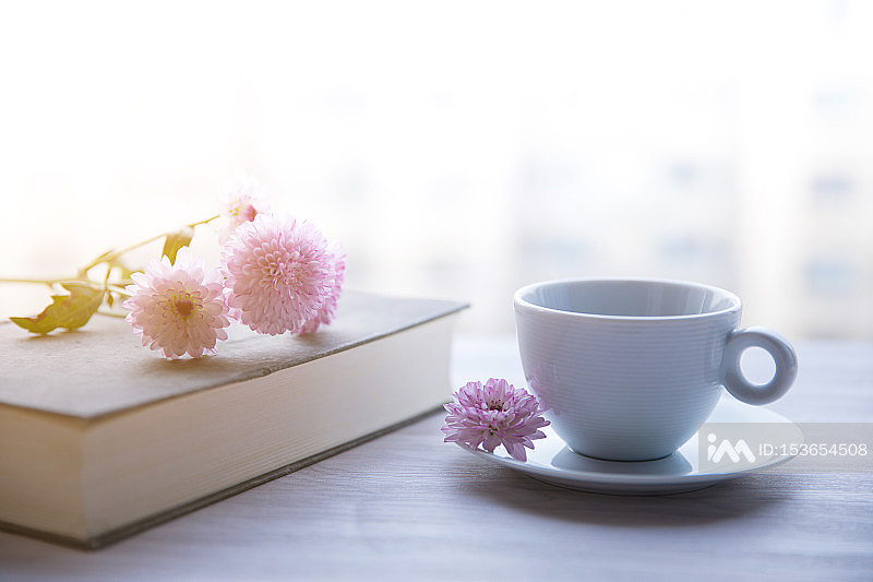 书本上的鲜花咖啡杯照片摄影图片