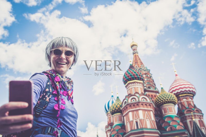 俄罗斯莫斯科红场上,一名女子在圣巴兹尔城堡前自拍正版图片素材