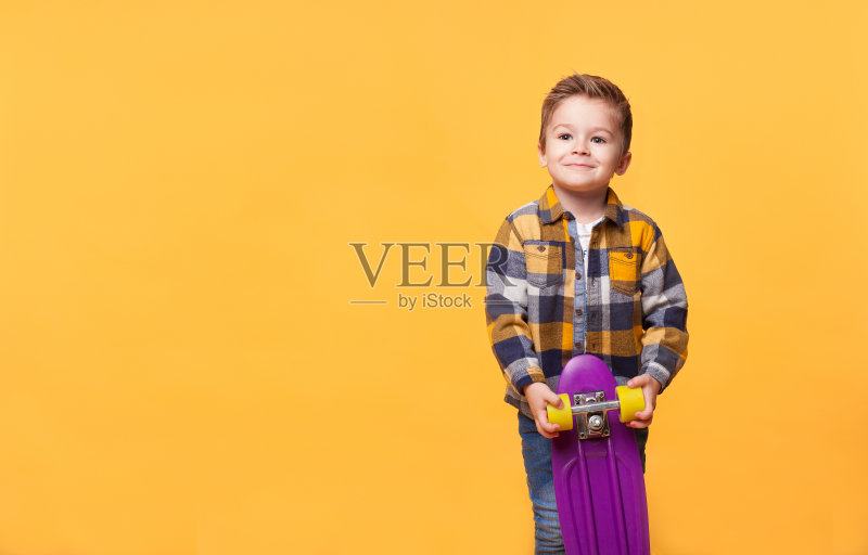 微笑的小男孩站在滑板上正版图片素材