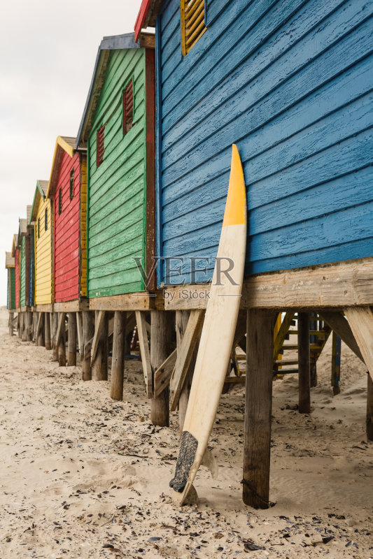 海滩上蓝色木屋旁的冲浪板正版图片素材
