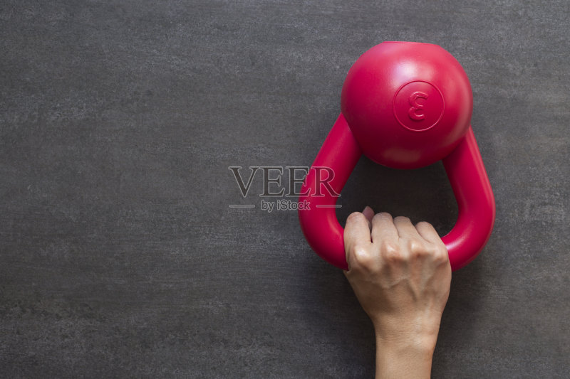 手拿壶铃在一个黑色的背景正版图片素材