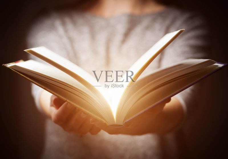 光从女人的手中的书在给予的手势正版图片素材