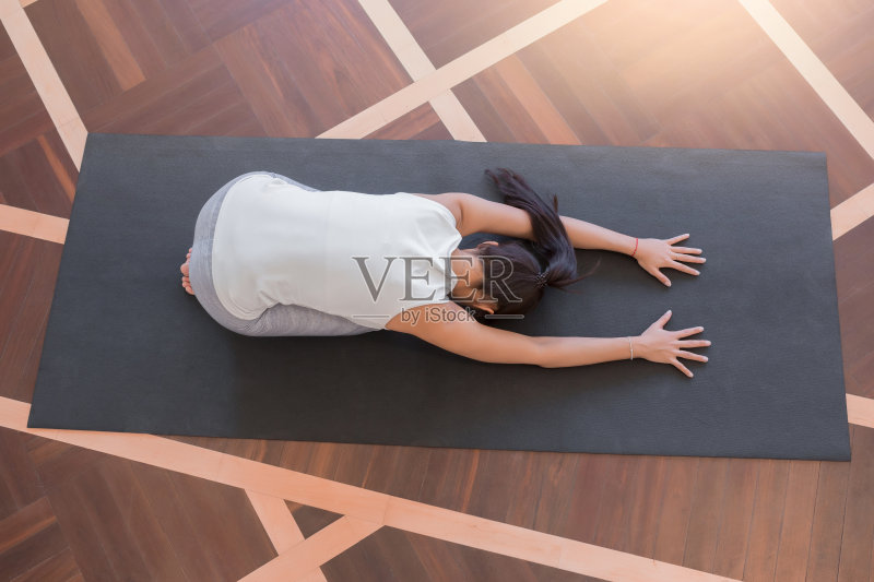 穿着白色衣服的年轻女子在做瑜伽姿势正版图片素材