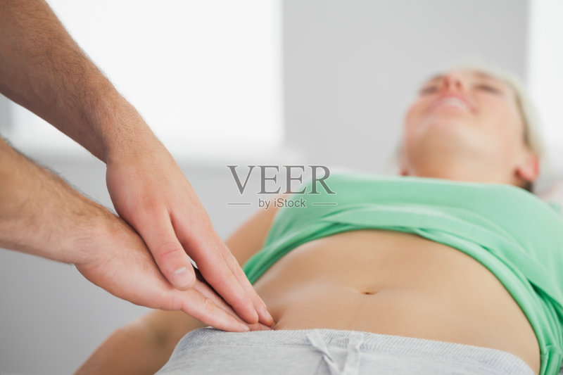 理疗师按压患者骨盆正版图片素材