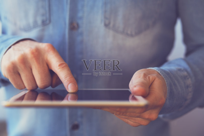 手持白色数码平板电脑的男子正版图片素材