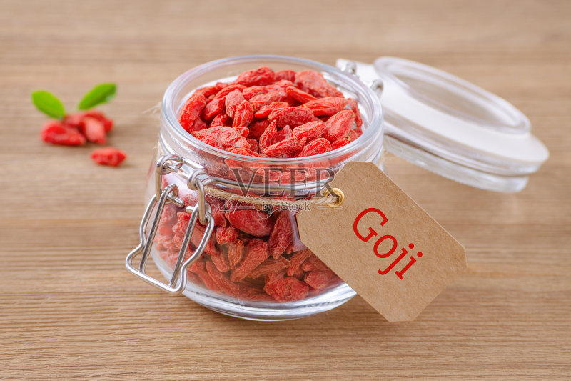 木制背景上的玻璃罐装枸杞正版图片素材