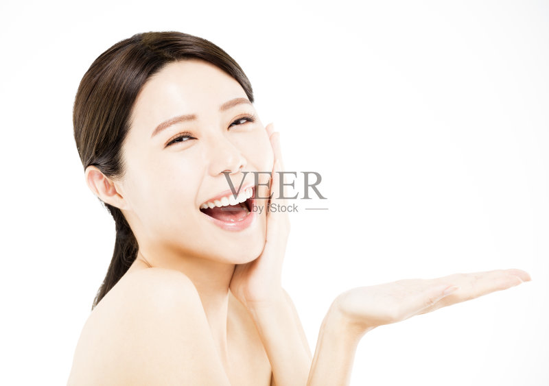 快乐的美女在她的手上展示美容产品正版图片素材