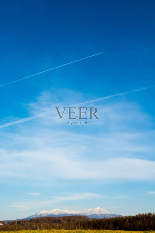 水汽在秋日的天空和雪山上留下痕迹正版图片素材