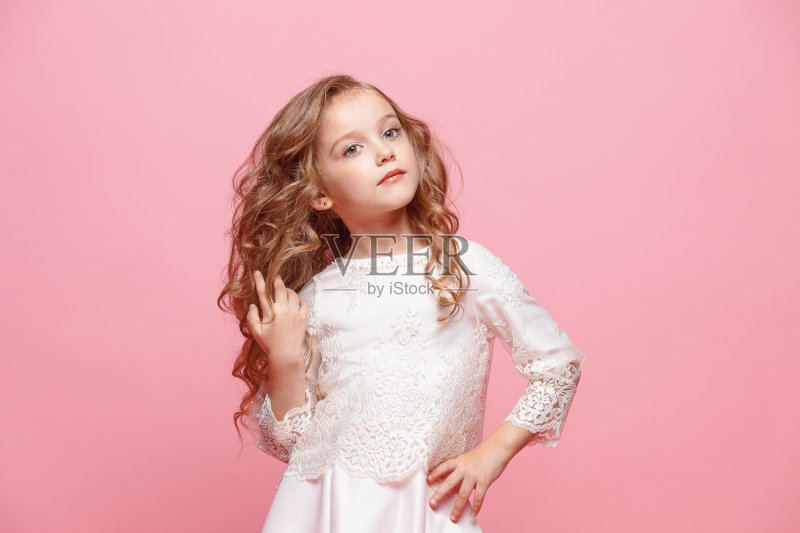 漂亮的小女孩穿着裙子站在白色的背景上摆姿势正版图片素材