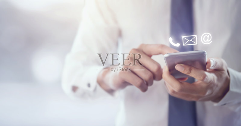 联系我们,商人手握手机(邮件,电话,电子邮件)正版图片素材