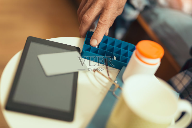 老人手里拿着药盒正版图片素材