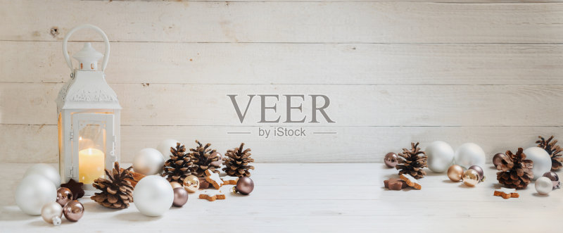宽阔的圣诞背景蜡烛灯,小装饰品,肉桂星和锥在乡村白色木材,全景格式的网站横幅,拷贝空间正版图片素材