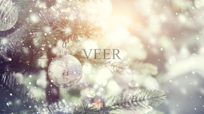 白色和银色的小装饰品挂在装饰好的圣诞树上。正版图片素材