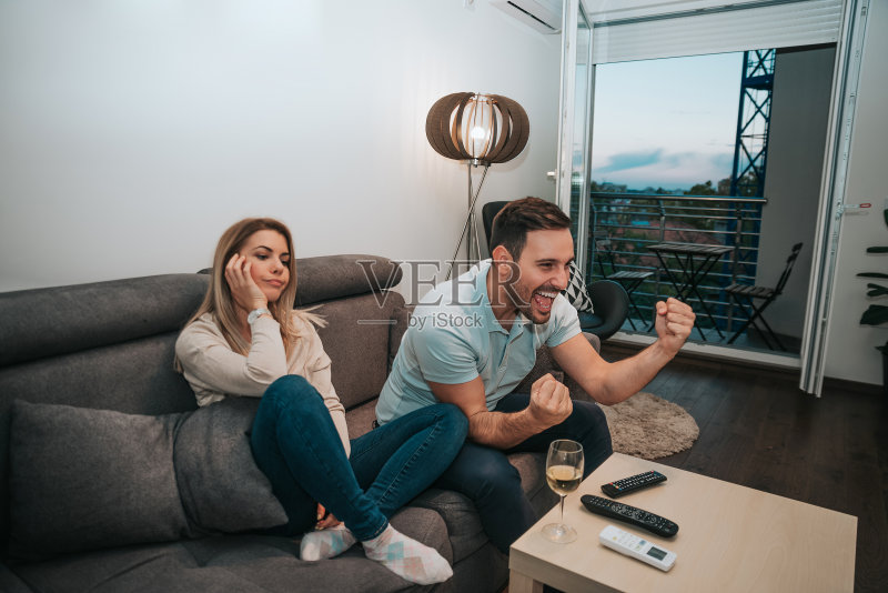 男人在看足球赛,女友在一旁感到无聊正版图片素材