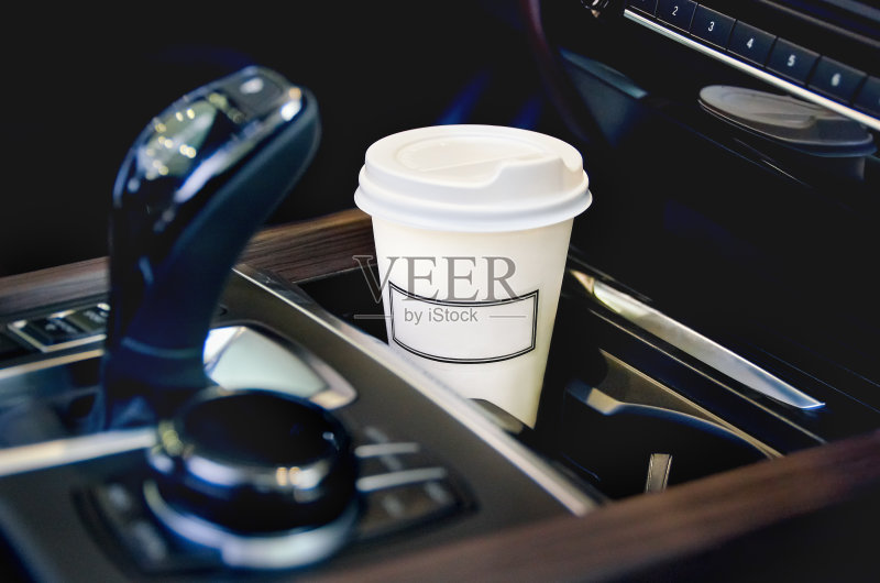 在汽车沙龙喝咖啡。汽车杯架里的一个纸咖啡杯。正版图片素材