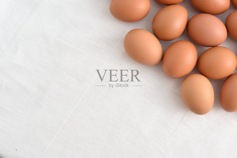 新鲜的棕色鸡蛋在白色织物的背景正版图片素材