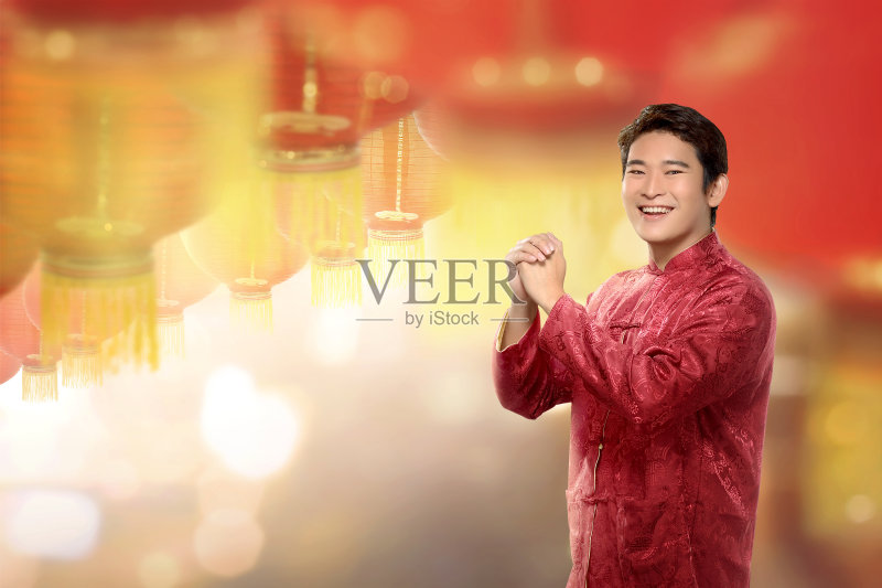 年轻的中国男子站在旗袍,挂着灯笼正版图片素材