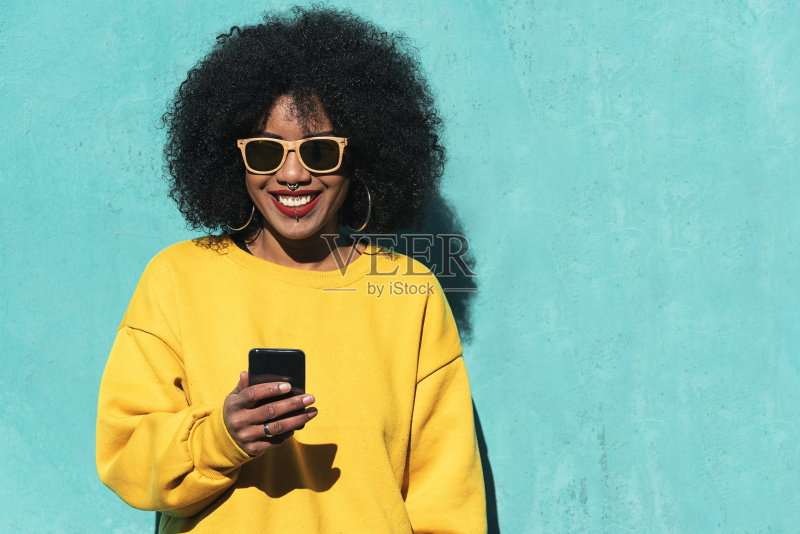 美丽的非洲裔美国女人在街上用手机。正版图片素材